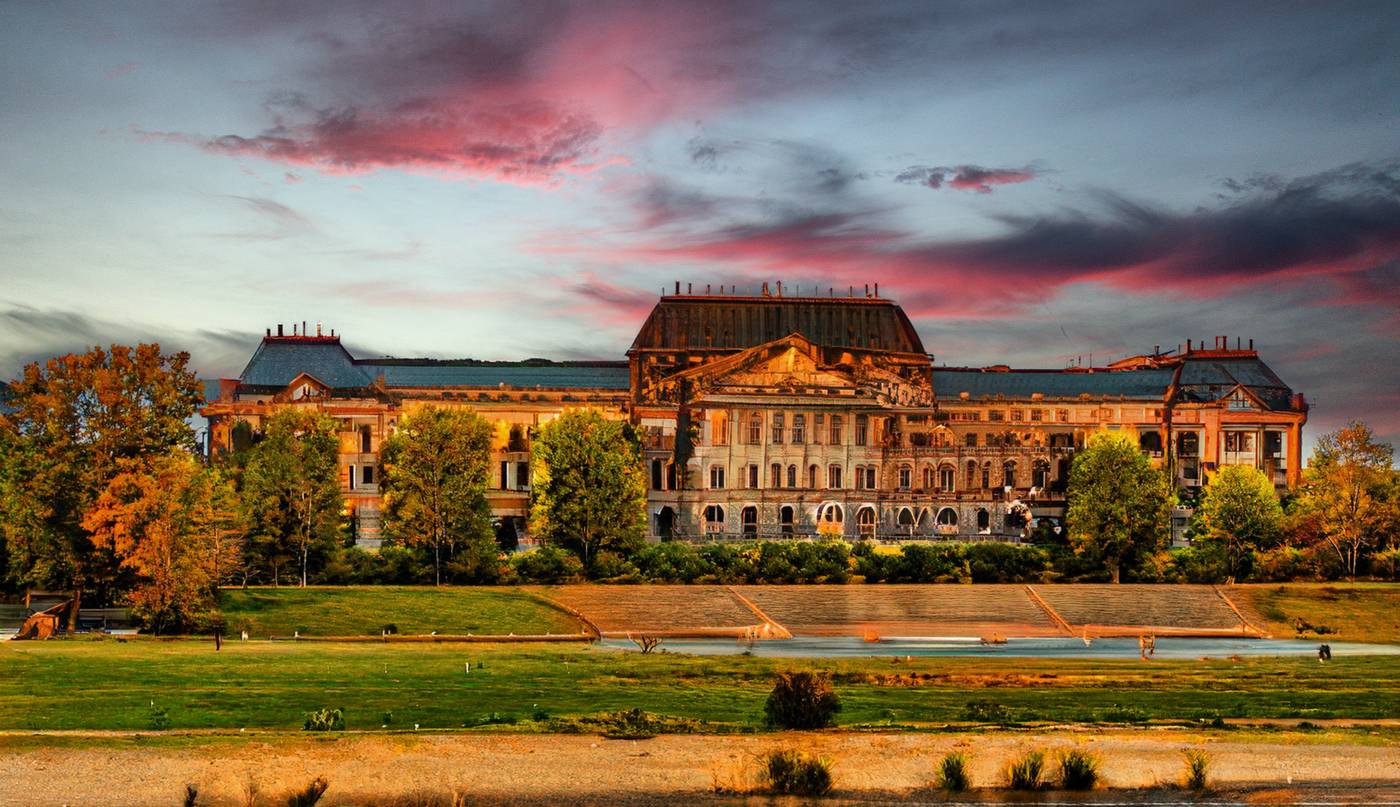 Historisches Gebäude am Fluss unter rosa Abendwolken